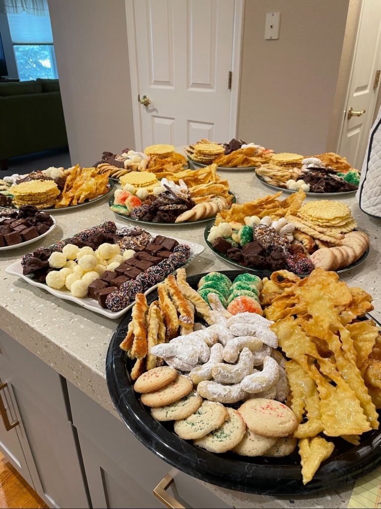 A kitchen counter filled with platters of assorted cookies and pastries