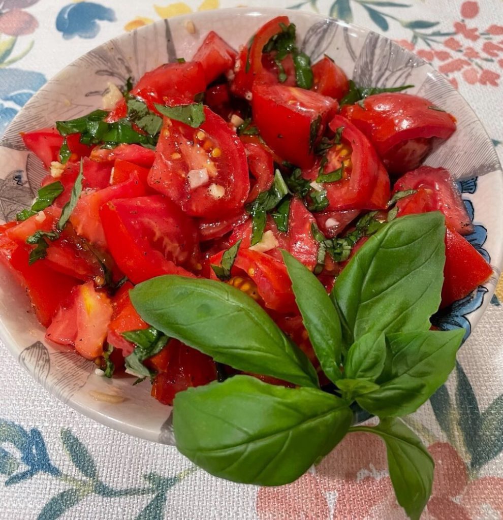 A bowl of tomato salad with fresh basil