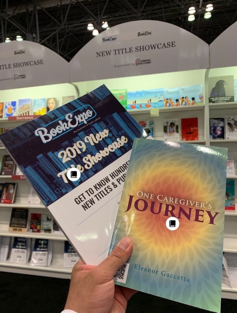 A person holding two books at a book fair