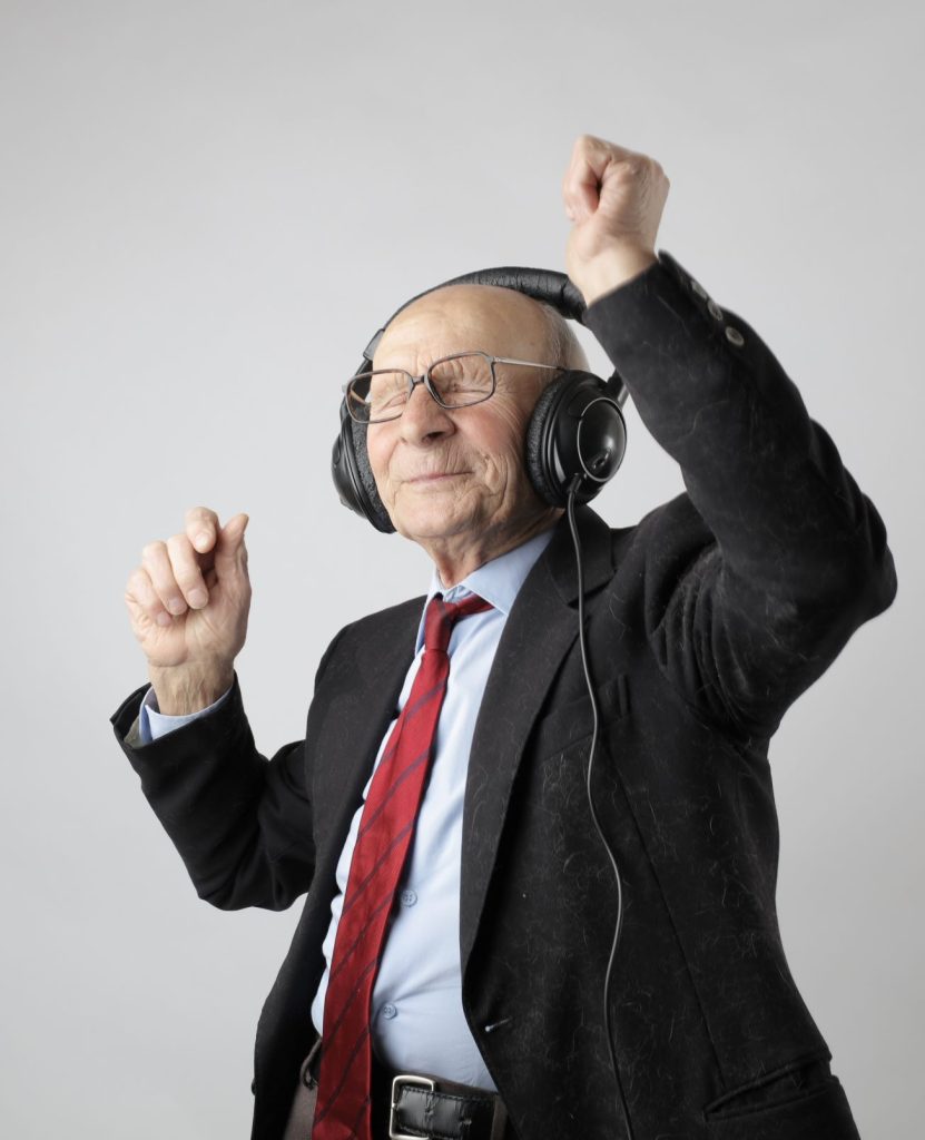 old man in suit listening to headphone