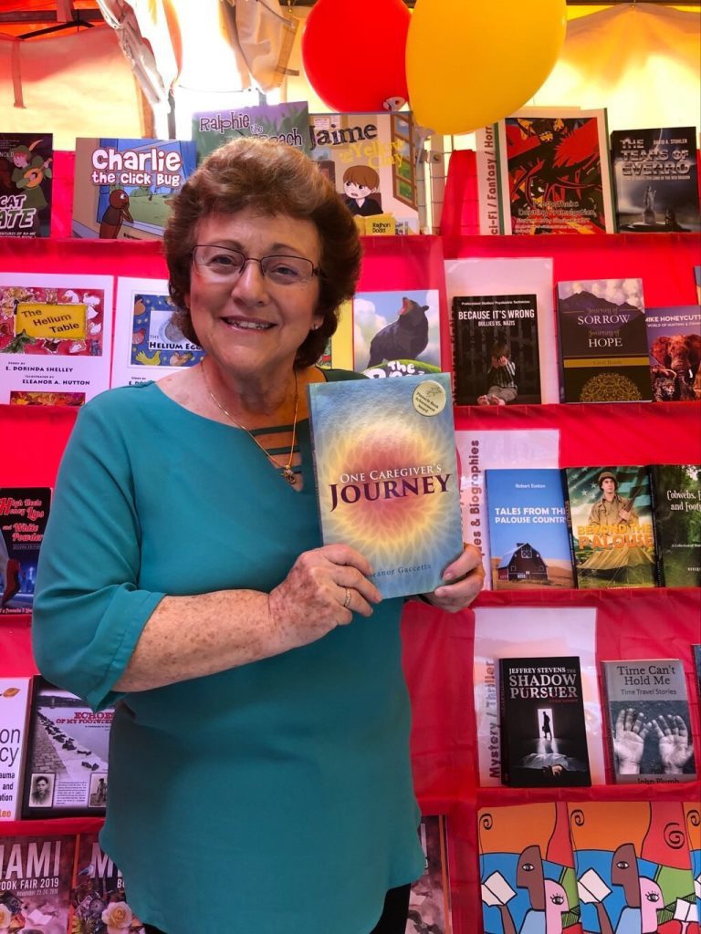 Elie holding a copy of One Caregiver's Journey