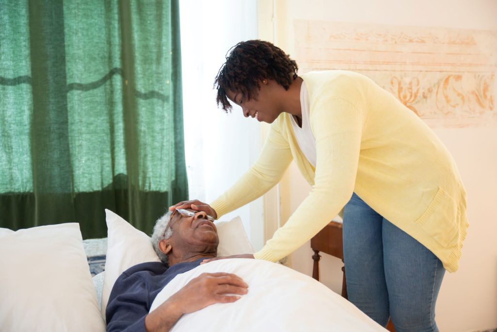 Talking About Age with the Elderly old man in bed attended by a woman