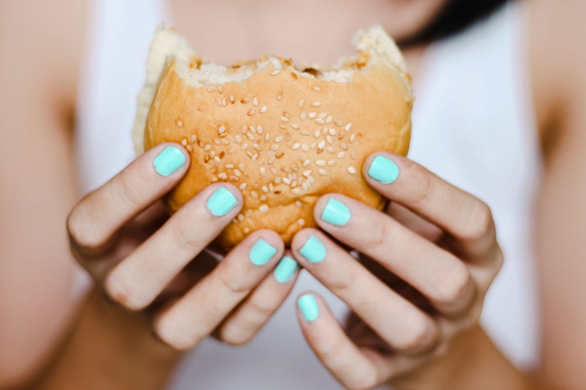 The Power of Comfort Food hand holding a burger