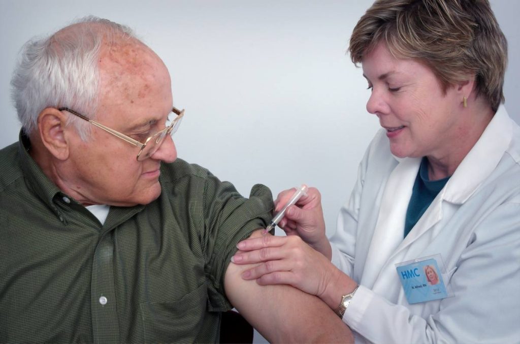 nurse injecting senior man role of family caregivers