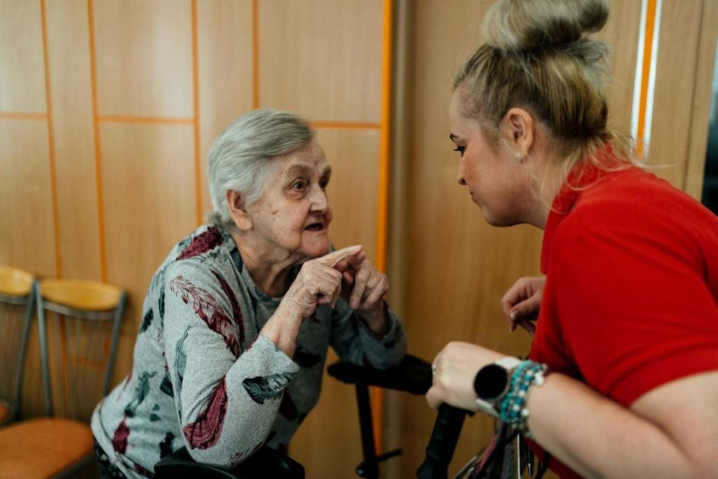 elderly woman talking to caregiver emotional burden of life as a caregiver