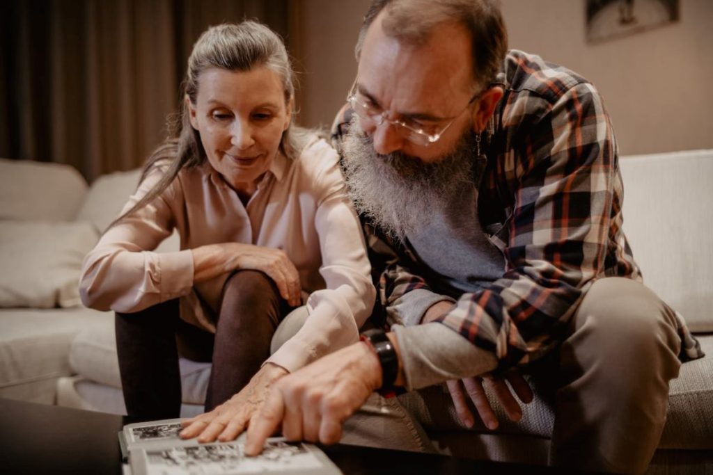 man and woman looking at photo album preserving the memories of a loved one