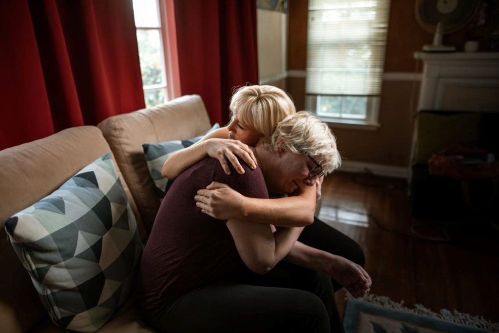 woman hugging crying man how a family grieves