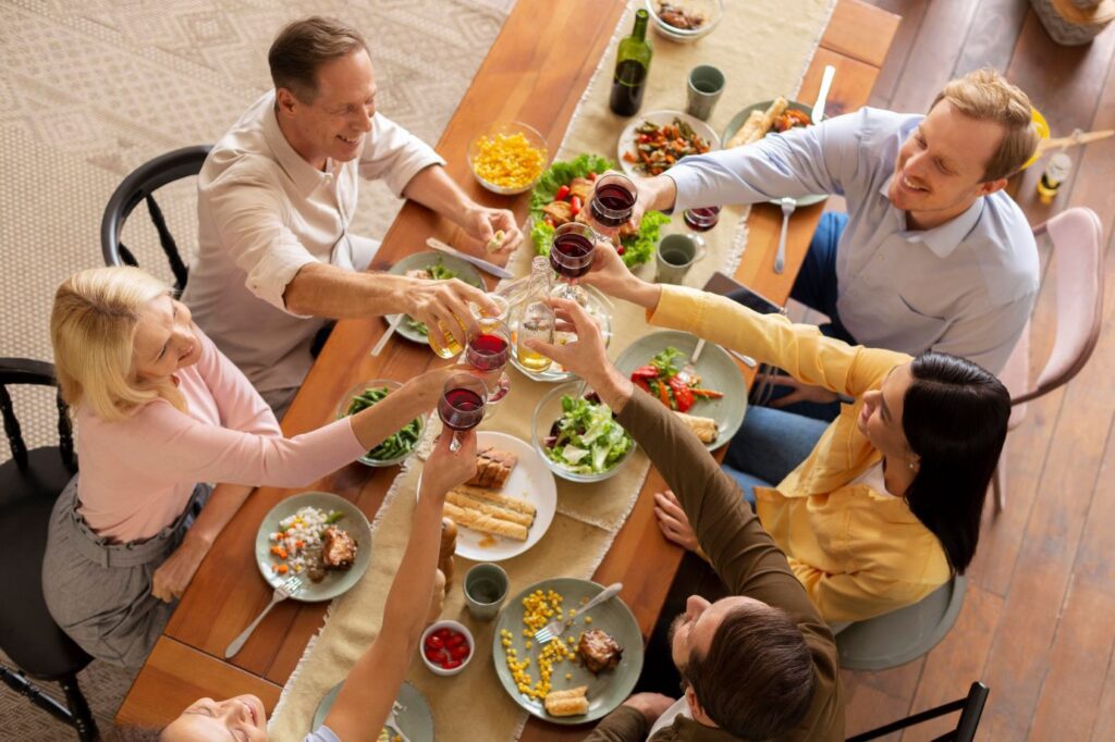 a photo of people eating together and sharing a toast