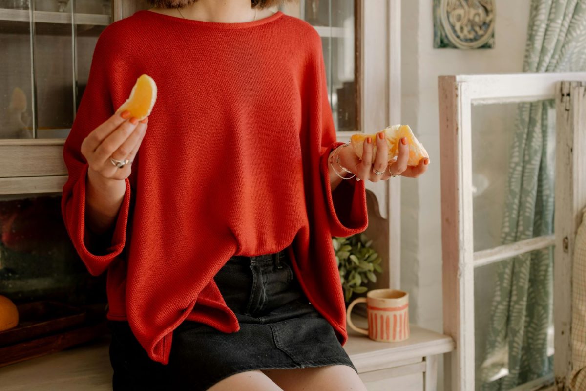 a photo of a woman eating oranges and showing how to eat mindfully