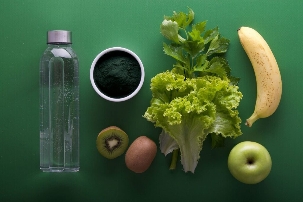 A bottle of water, powdered tea, and fruits and vegetables