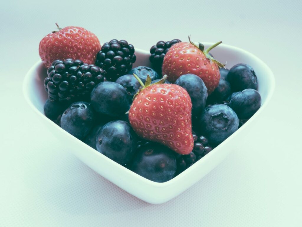 A heart-shaped bowl of fruits, illustrating the best diet for health heart.