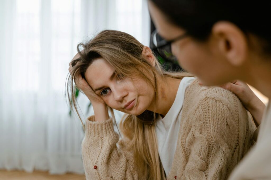 Person comforting a tired person, depicting ways for supporting the emotional labor of caregivers | Photo by MART PRODUCTION