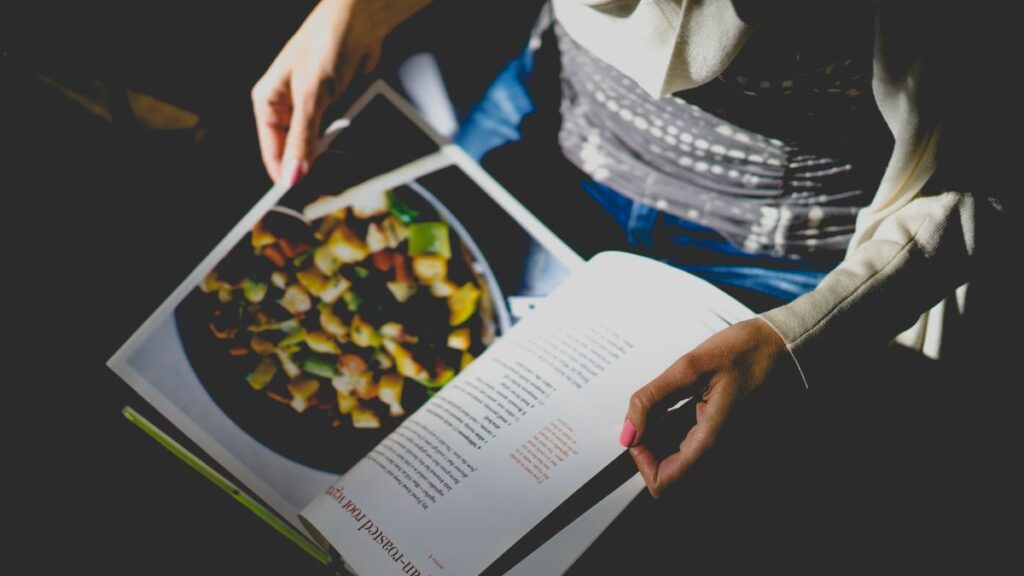 A person reading a cookbook, embracing the emotional power of generational recipes.
