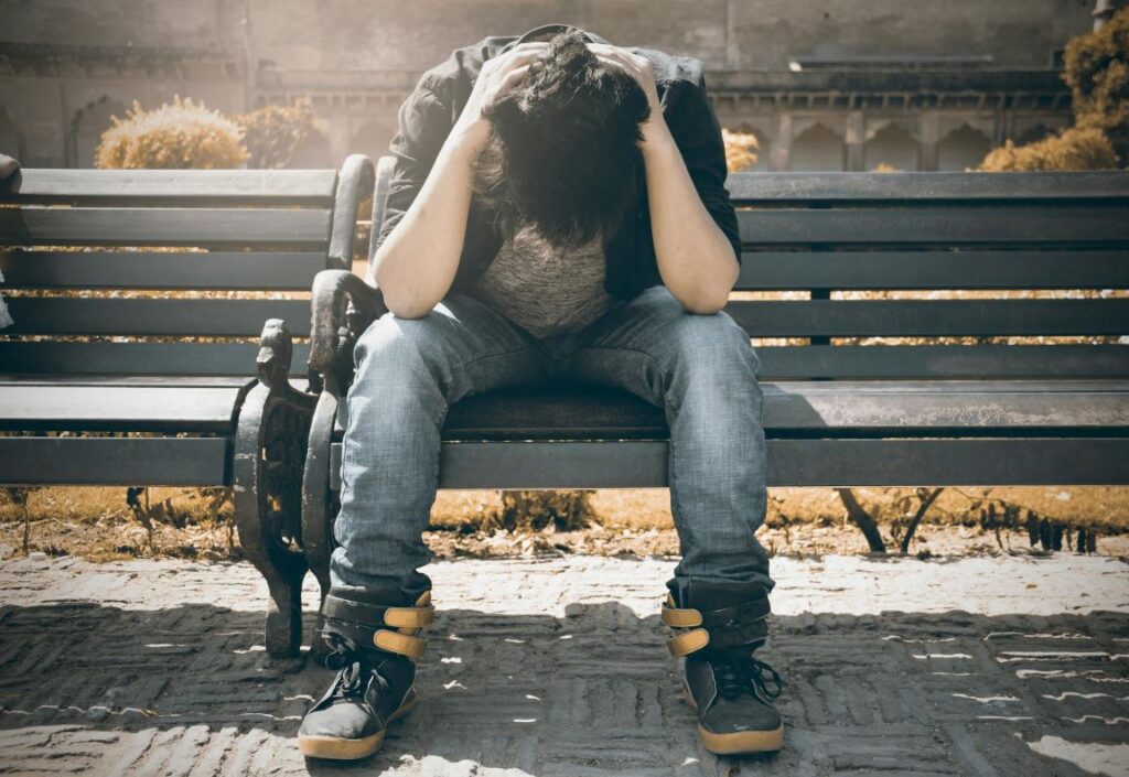 A man holding his head down in guilt.