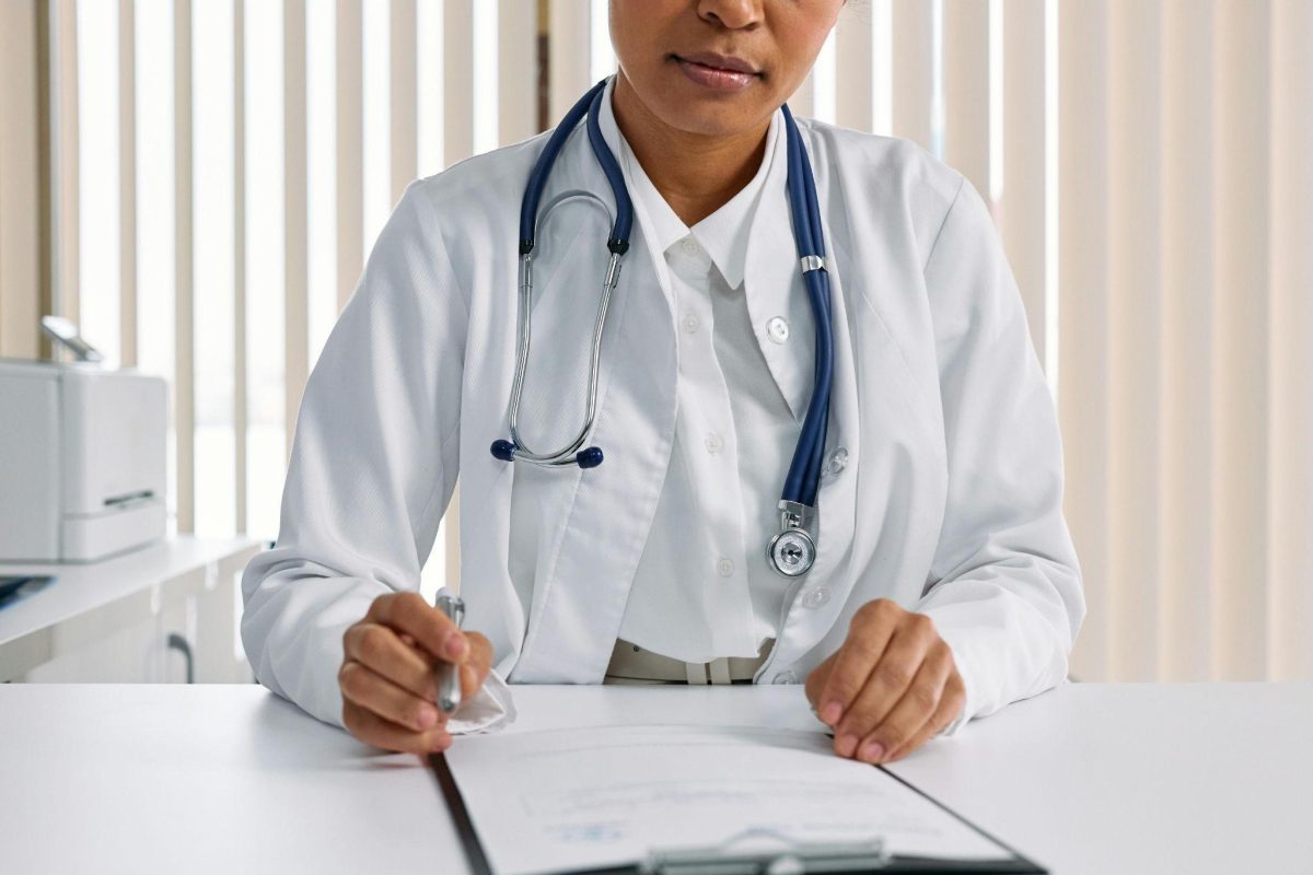 A doctor in preparation to handle a patient, showcasing the essence of caregiver checklist for doctor visits.