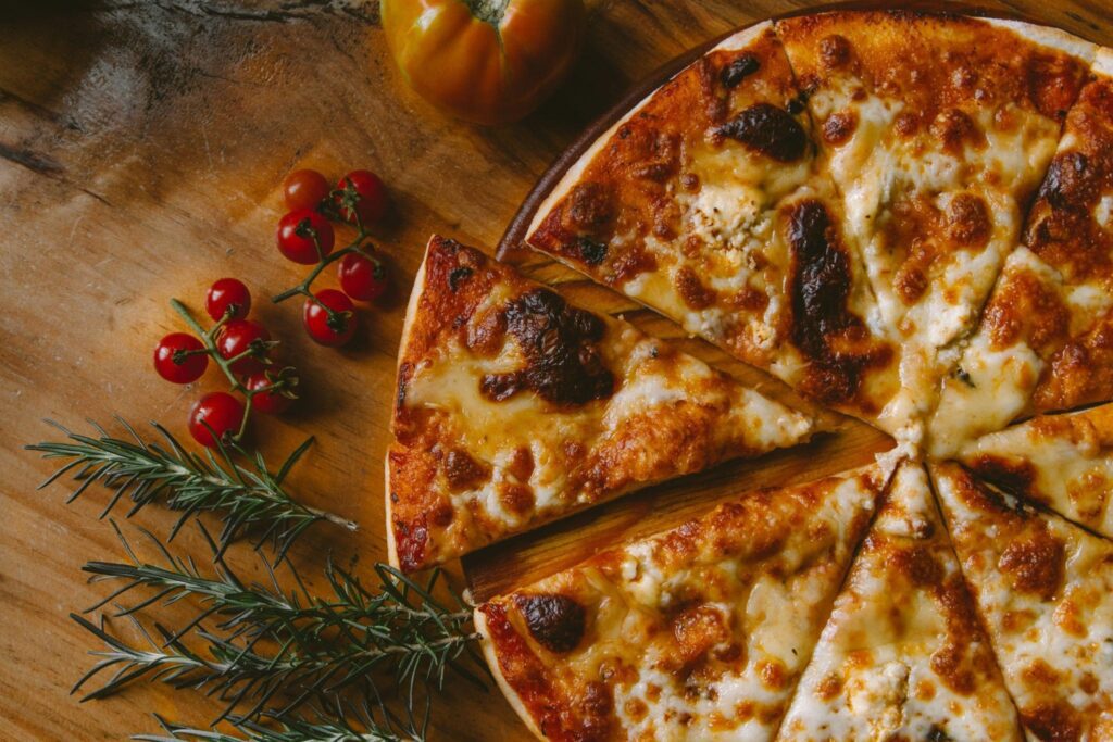 Photo of a pizza with a sliced piece, showcasing the use of Neapolitan pizza recipe for beginners.