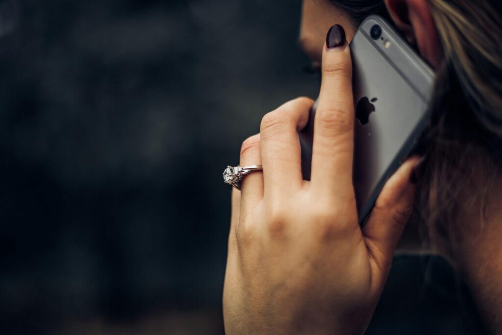 A woman on her phone, calling and utilizing emergency contact list for caregivers.