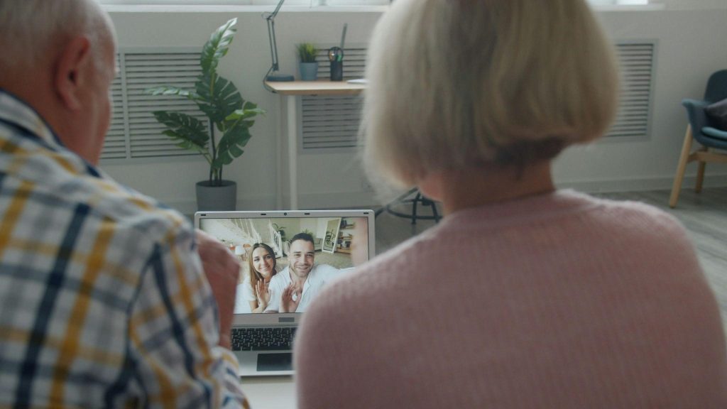 Two elderly individuals engaging in online Alzheimer’s caregiver groups.