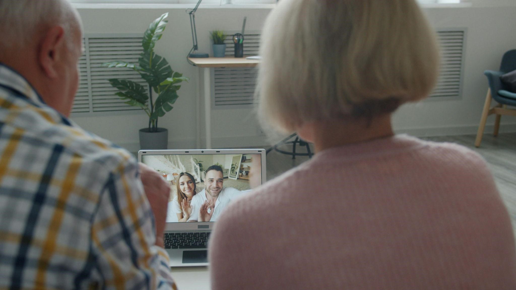 Two elderly individuals engaging in online Alzheimer’s caregiver groups.