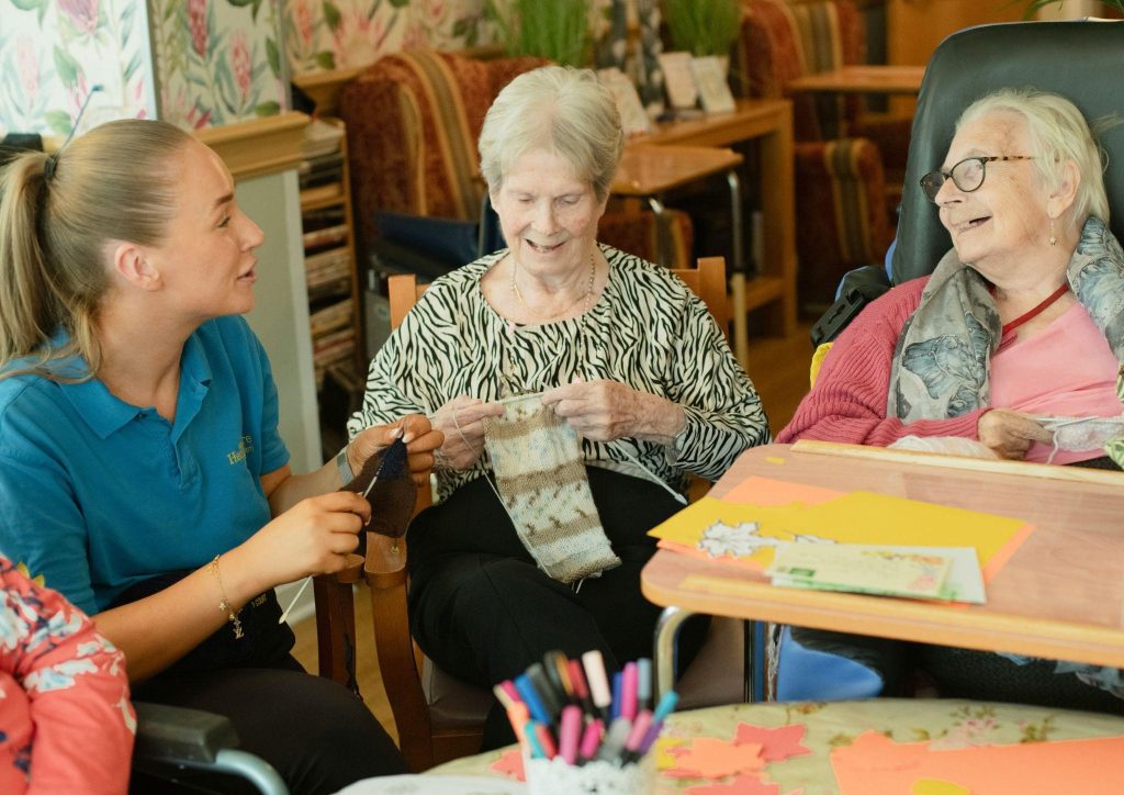 A caregiver conversing with elderly ladies, depicting local social groups for caregivers.