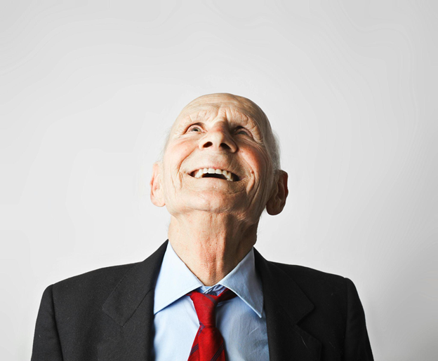 Elderly man smiling and looking up.