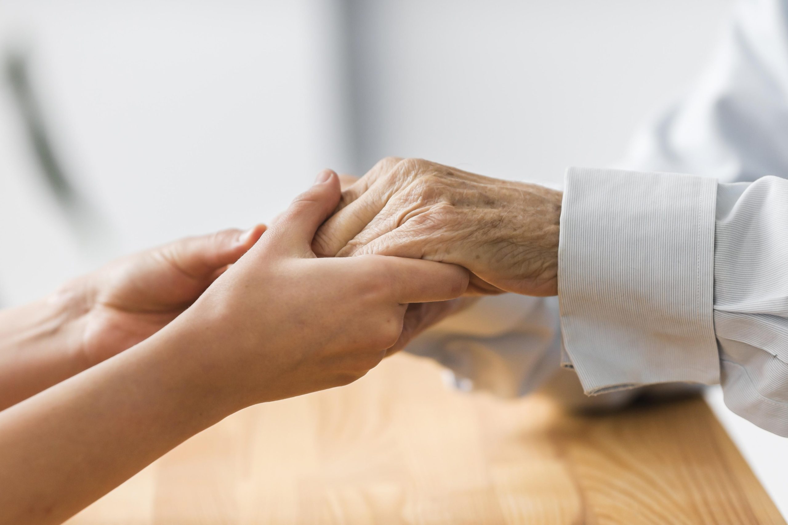 A young woman holding a senior's hand | Image Source: Freepik