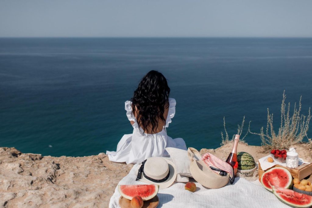 A woman having a picnic on the beach.