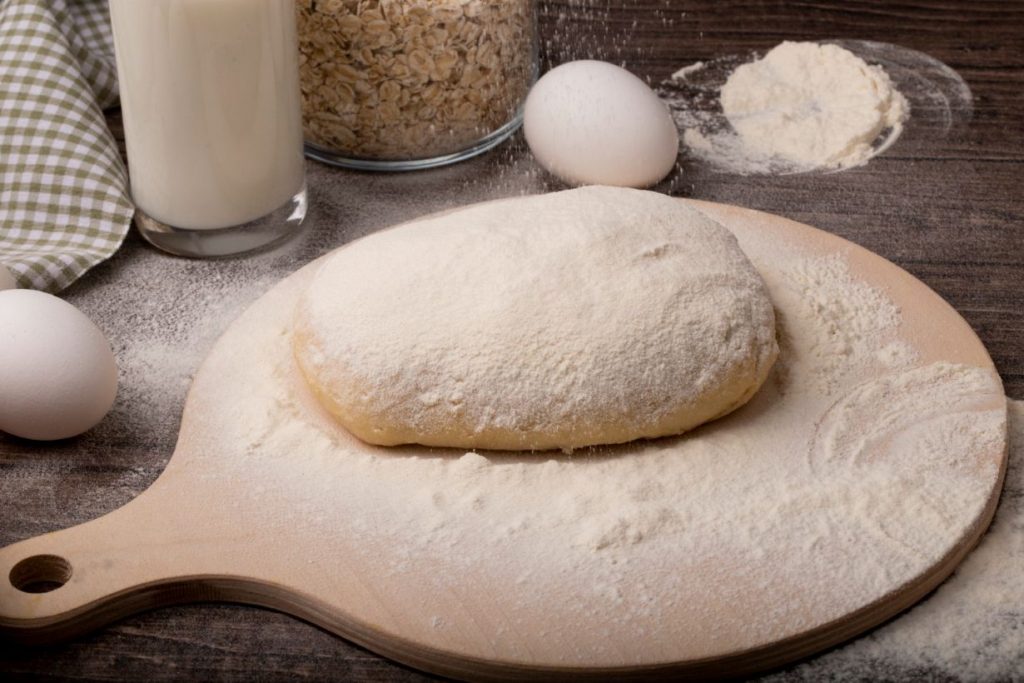 Bread dough sprinkled with flour on a cutting board.