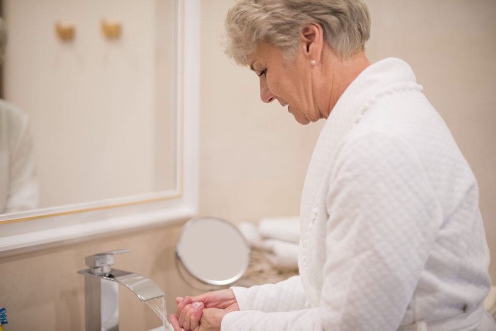 An old woman preparing to bathe.