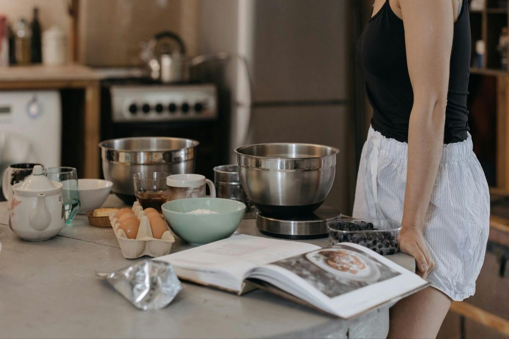 A person stands at a kitchen counter, engaging in holiday meals for beginner home cooks.