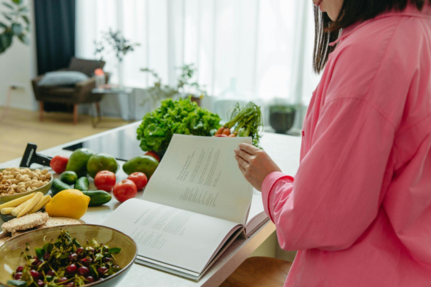 A new home cook reads a cookbook in a kitchen, immersing in beginner cooking tips.