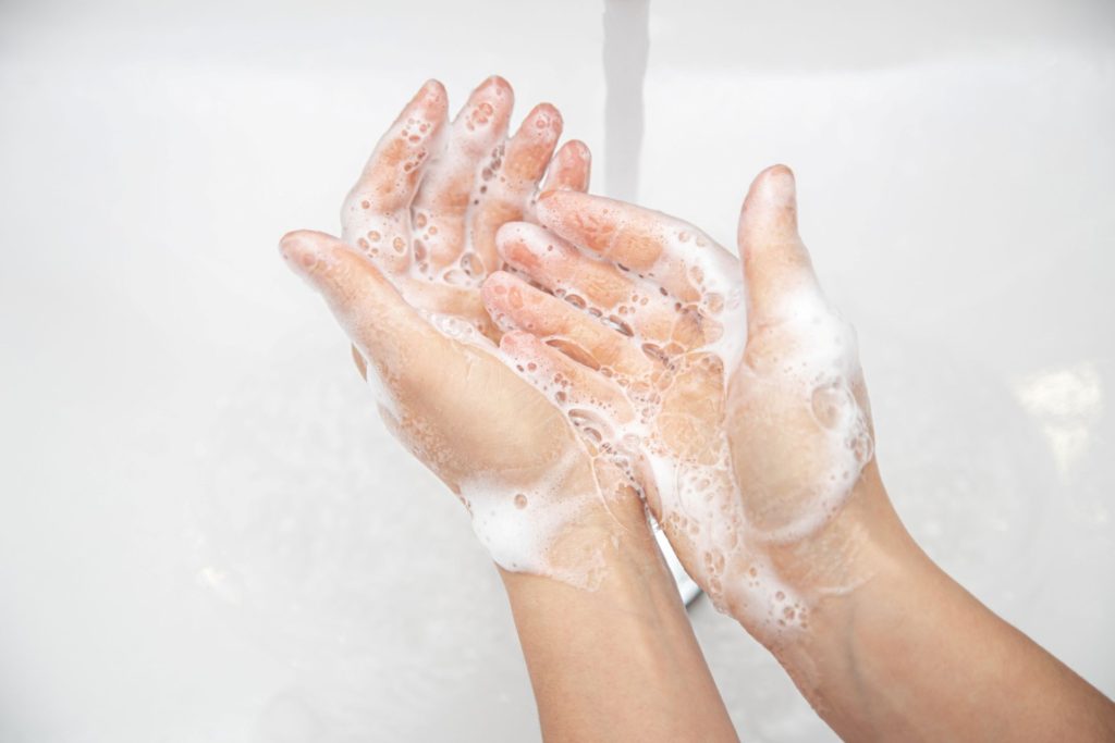 A pair of soapy hands being washed.