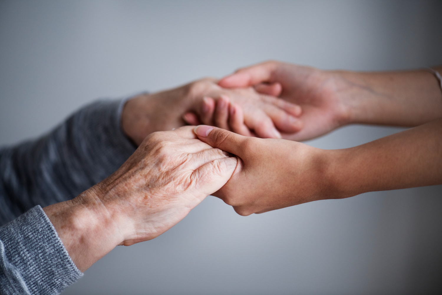A woman holding hands with an elderly