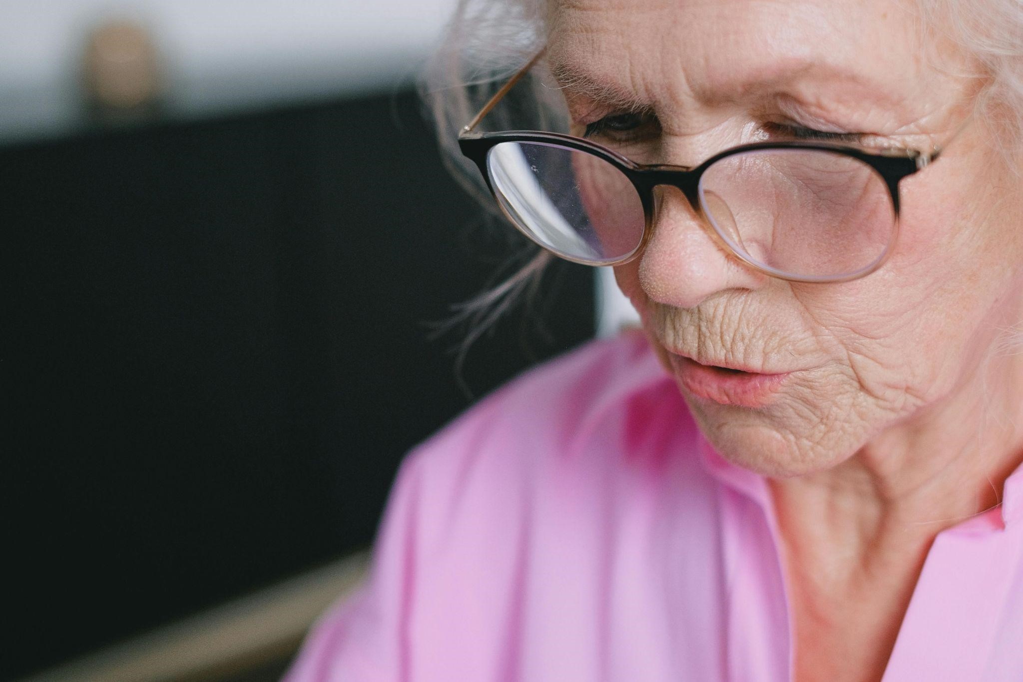 Elderly woman looks focused and contemplative while talking, depicting how dementia patients talk to themselves.