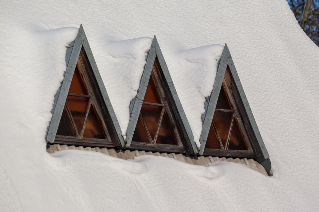 Window frames peeking out of a pile of snow.