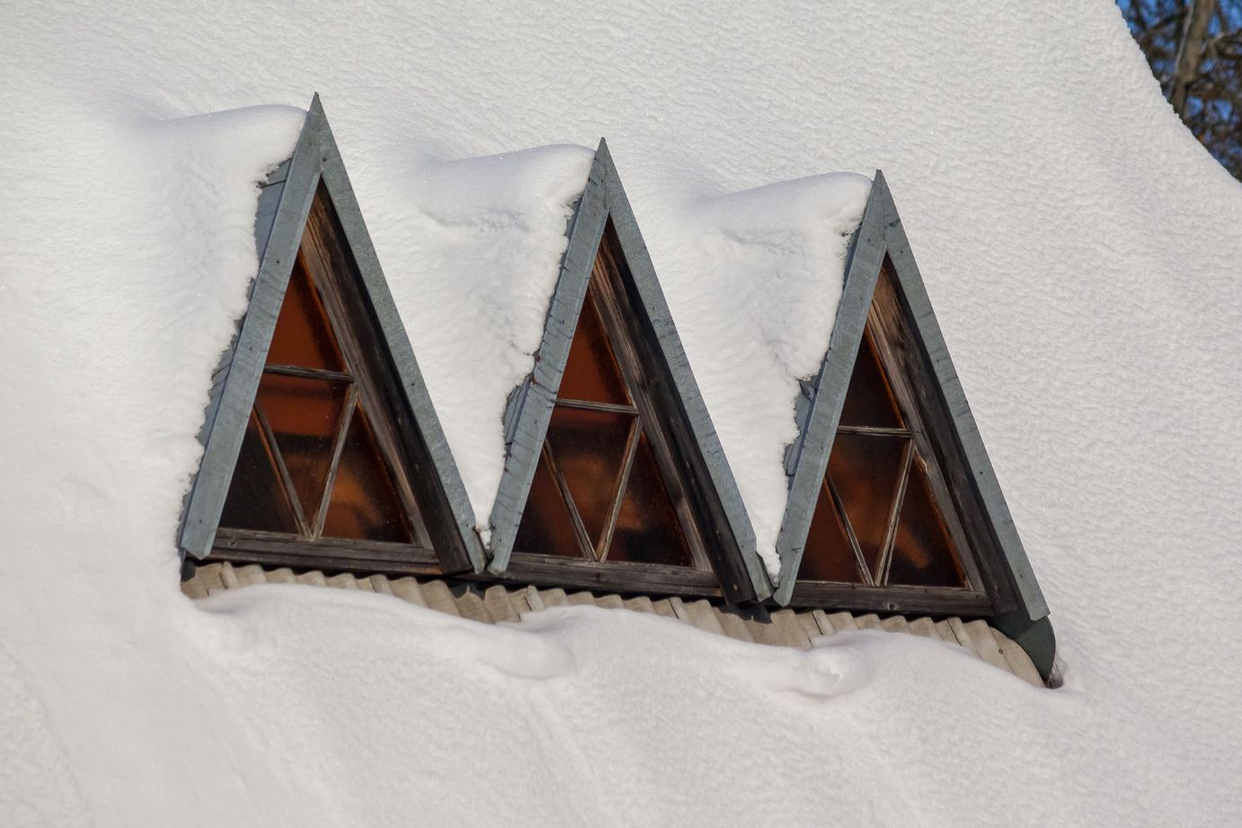 Window frames peeking out of a pile of snow.