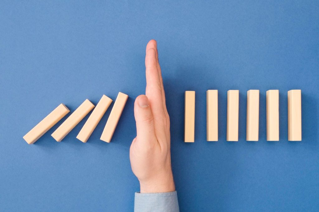 Hand blocking dominoes | Drawing the line between care and self-preservation is important.