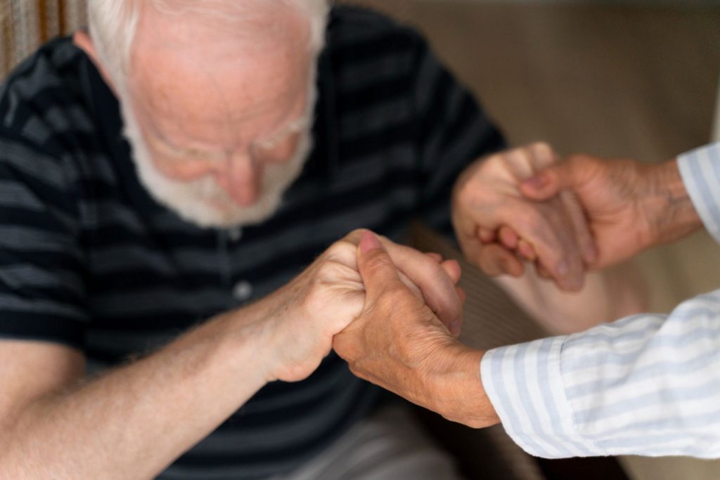 Older man getting help standing up.