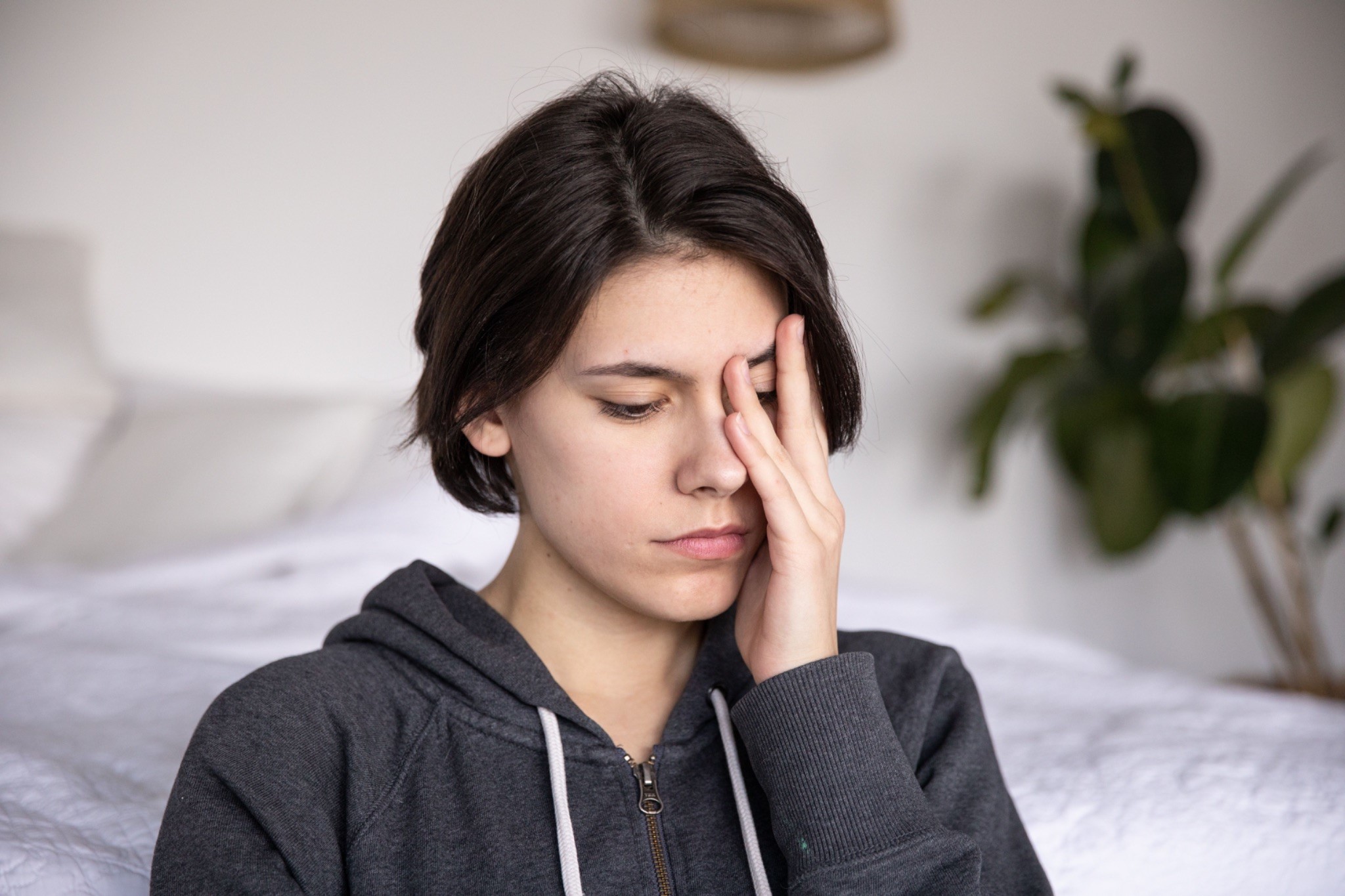 A woman covers her face with her hands, expressing why caregiving is emotionally demanding.