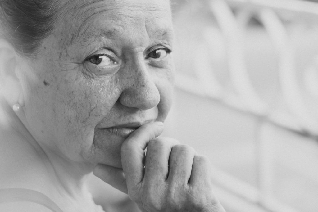 Aged woman facing the camera gently.